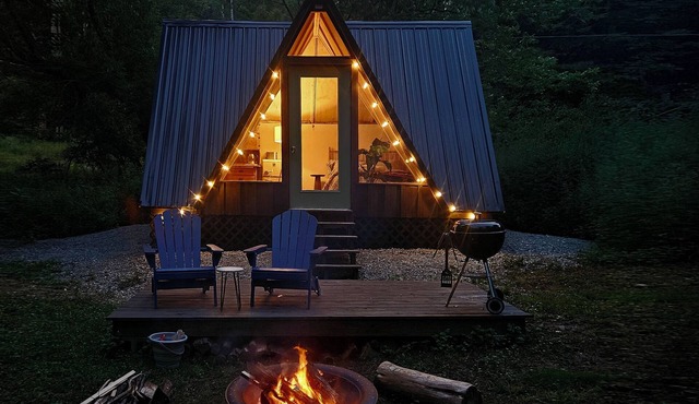 Cozy A-frame cabin surrounded by trees in Keene