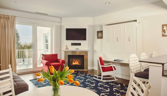 Experience luxury at Captain Suite 219 in Bay Harbor, MI, featuring a cozy bedroom and village view.