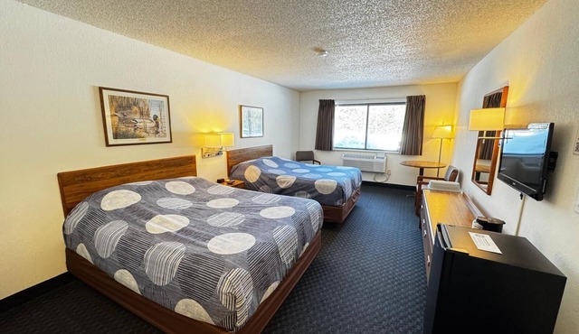 Stay in comfort in this room featuring two queen beds, a private bathroom, sitting area, mini fridge, and single-serve coffee maker. Guests also have access to a microwave in the lobby. Perfect for couples, friends, or families looking for a cozy and