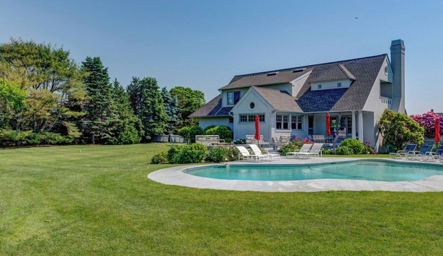 Traditional-style home with private pool, sweeping back deck, grand lawn,.